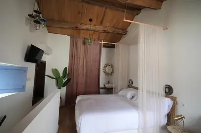 a bedroom with a white bed and a television at HOTEL CASAS DA FORTALEZA Casa do Garda in Outeiro de Rei