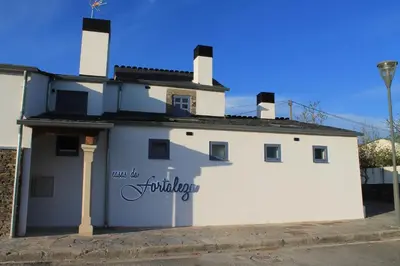 a white building with a sign on the side of it at HOTEL CASAS DA FORTALEZA Casa do Garda in Outeiro de Rei