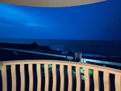 a view of the ocean at night from a bench at Apartamento Oceano in Barreiros