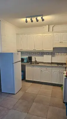 a kitchen with white cabinets and a refrigerator at Apartamento Oceano in Barreiros