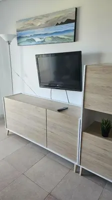 a flat screen tv sitting on top of a entertainment center at Apartamento Oceano in Barreiros