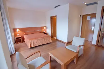 a hotel room with a bed and a table and chairs at Hotel Torques in A Coruña