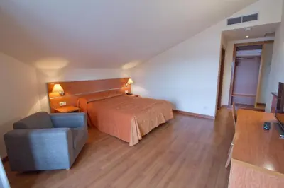 a hotel room with a bed and a couch at Hotel Torques in A Coruña