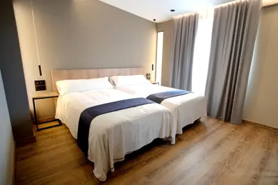 a bedroom with a large bed with white and blue sheets at HOTEL RIO LEA in Castro de Rey