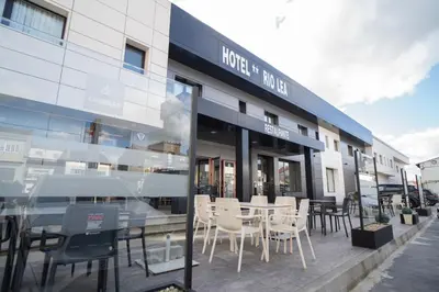 a restaurant with tables and chairs outside of a building at HOTEL RIO LEA in Castro de Rey