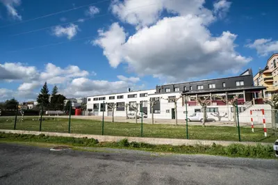 a white building with a fence in front of it at HOTEL RIO LEA in Castro de Rey