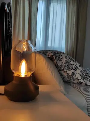 a lit candle in a glass jar on a table at La Casa del Camino in Santiago de Compostela