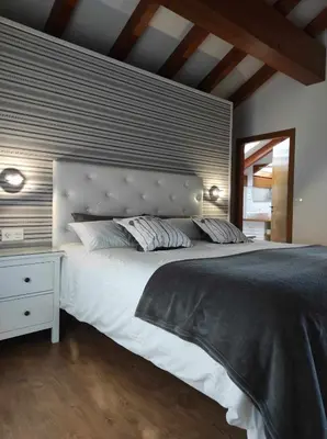 a bedroom with a large white bed and a mirror at La Casa del Camino in Santiago de Compostela