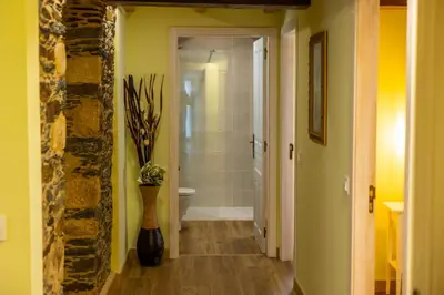 a hallway with a bathroom with a toilet and a vase at Apartamentos Casona del Campo in Navia