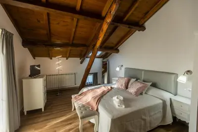 a bedroom with a bed and wooden ceilings at Apartamentos Casona del Campo in Navia