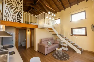 a living room with a staircase and a couch at Apartamentos Casona del Campo in Navia
