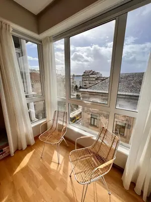 two chairs in a room with large windows at Apartamentos San Martín Ourense Centro 1 in Ourense