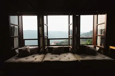 a couch sitting in front of a large window at Apedeceo Belesar Villa, Ribeira Sacra, Galicia in Chantada