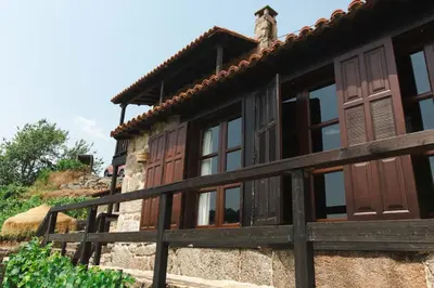 a house with wooden doors and a fence at Apedeceo Belesar Villa, Ribeira Sacra, Galicia in Chantada