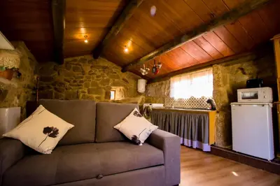 a living room with a couch in a kitchen at A Casiña dos Canastros in Barcia