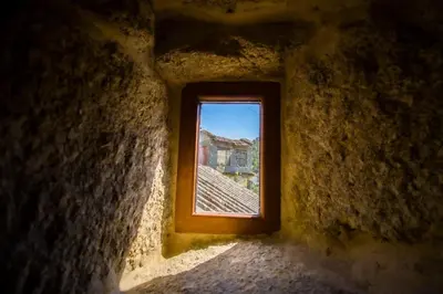 a window in a wall with a view of a building at A Casiña dos Canastros in Barcia