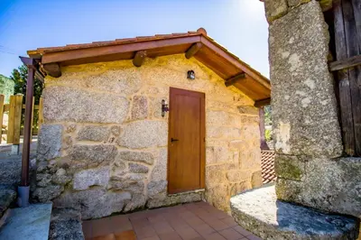 a door on a stone building with a wooden roof at A Casiña dos Canastros in Barcia