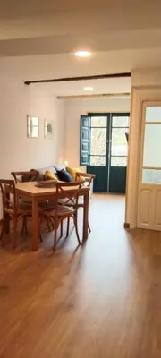 a living room with a wooden table and chairs at El Volante Alojamiento Turístico in Villafranca del Bierzo