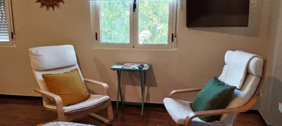 two chairs and a table in a room with a tv at El Volante Alojamiento Turístico in Villafranca del Bierzo