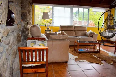 a living room with a couch and a stone wall at A Beira da Cortella in Melón