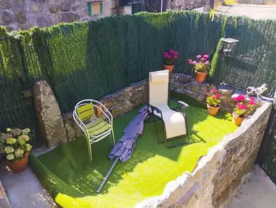 a miniature garden with an umbrella and a chair at A Beira da Cortella in Melón