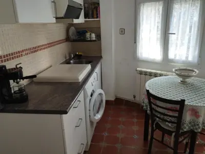 a kitchen with a sink and a washing machine at A Beira da Cortella in Melón
