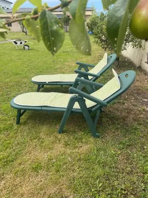 two chairs and a bench sitting in the grass at Viviendas uso turístico REME I in Foz