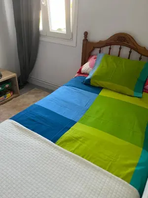a bed with a colorful blanket on top of it at Viviendas uso turístico REME I in Foz