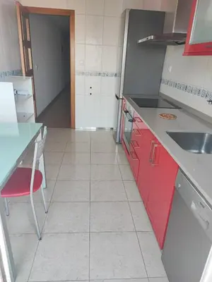 a kitchen with red cabinets and a red chair at MARINA SOL VIVEIRO in Viveiro