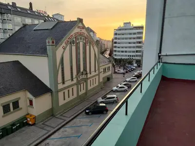 arial view of a building with cars parked on a street at Piso centrico en Ribadeo in Ribadeo