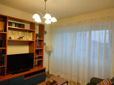 a living room with a television and a large window at Piso centrico en Ribadeo in Ribadeo