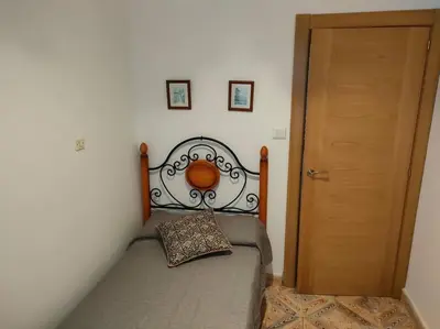 a bedroom with a bed next to a wooden door at Piso centrico en Ribadeo in Ribadeo