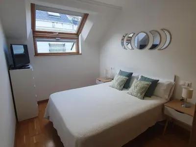 a bedroom with a white bed and a window at Miramar in Viveiro
