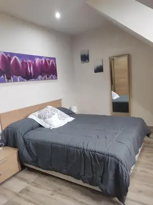 a bedroom with a bed and a painting on the wall at Casa da Escuela in Caldas de Reis