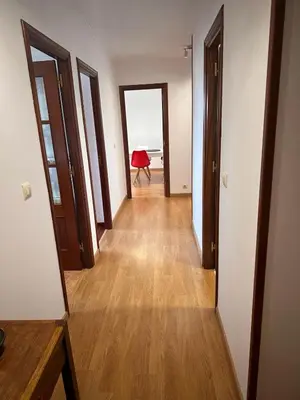 a hallway of an apartment with a red chair in the distance at PISO OROSO NO CAMIÑO in Sigüeiro