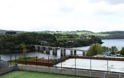 a view of a tennis court next to a body of water at Pensión Boavista in Portomarin