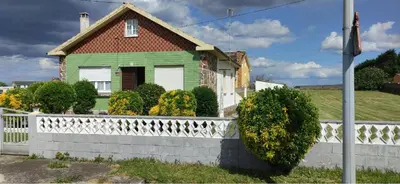 a green house with a white fence at Casa Eusebio de Veva in Rinlo
