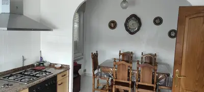 a kitchen with a stove and a table with chairs at Casa Eusebio de Veva in Rinlo