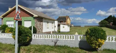 a house with a retaining wall and a fence at Casa Eusebio de Veva in Rinlo