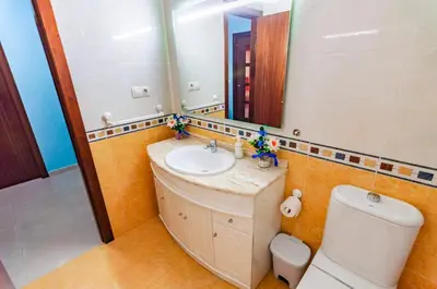 a bathroom with a sink and a toilet and a mirror at San Francisco in Viveiro