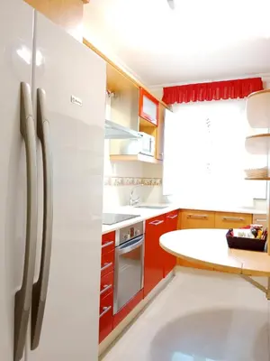 a kitchen with a white refrigerator and red cabinets at San Francisco in Viveiro