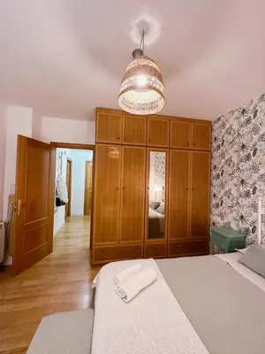 a bedroom with a bed and a chandelier at Apartamento Suite Los Deportes in Ponferrada