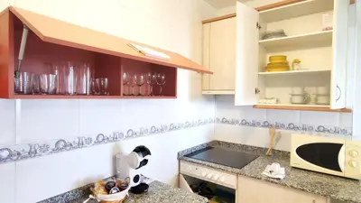 a kitchen with white cabinets and a counter top at Apartamento Suite Los Deportes in Ponferrada