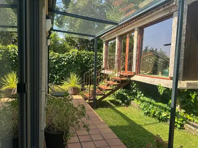 a screened in porch with a view of a garden at COTOLAI in Santiago de Compostela