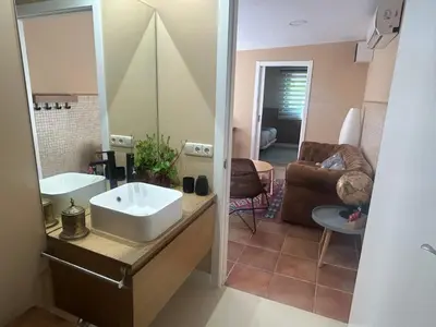 a bathroom with a sink and a living room at COTOLAI in Santiago de Compostela
