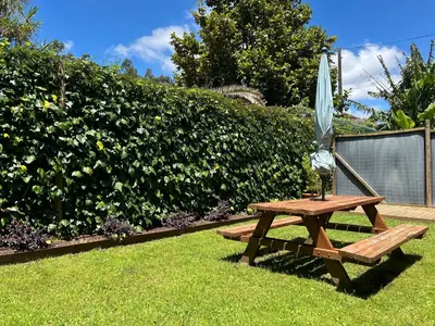 a wooden picnic table with an umbrella on the grass at COTOLAI in Santiago de Compostela