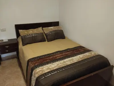 a bed in a room with a white wall at Casa Fuentefria in Ourense