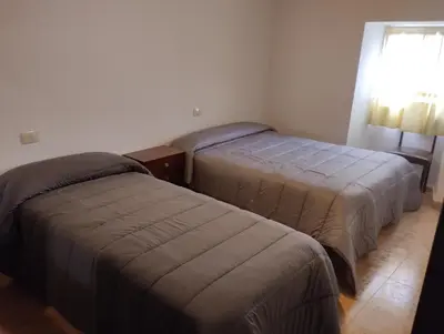 a bedroom with two beds and a window at Casa Fuentefria in Ourense