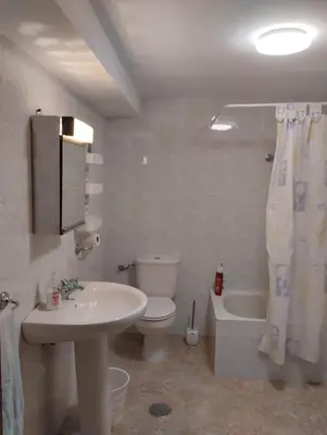 a bathroom with a sink and a toilet and a tub at Casa Fuentefria in Ourense