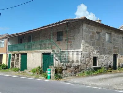 an old stone building on the side of a street at Casa Fuentefria in Ourense